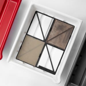 May include: A white plastic photo developing tray with a black grid and three compartments. The tray has the text "Zebra Dry Plates" printed on the bottom.