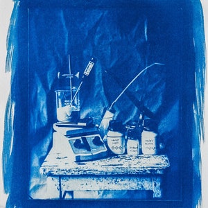 May include: A blue and white laboratory setup with a beaker, a stirring motor, and three glass jars labelled "Randy's Blend", "Speedo Mix", and "Randy's Blend".