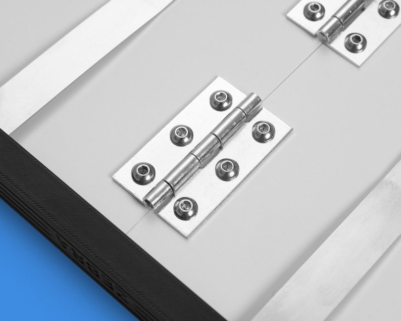 May include: Close-up of a silver hinge with multiple screws. The hinge is attached to a white surface.