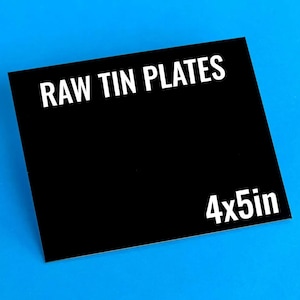 Pode incluir: Um sinal retangular preto com texto branco que diz "RAW TIN PLATES 4x5in".