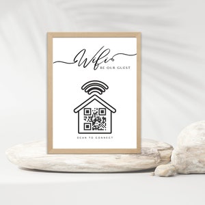 Op de afbeelding: Een printbaar bord met een zwart-witte illustratie van een huis met een wifi-signaal erboven en een QR-code erin. De tekst op het bord luidt "Wifi Be Our Guest" en "Scan to Connect".