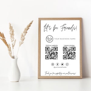 Op de afbeelding: Een wit ingelijst bord met de tekst "Let's be Friends!" en een logo dat "Your Logo Here" zegt. Het bord bevat ook de tekst "YOUR BUSINESS NAME", "Bezoek onze website", "Laat een recensie achter" en "Bedankt voor het steunen van ons kleine bedrijf!" Het bord bevat ook twee QR-codes en social media-iconen voor Instagram, Facebook, Twitter en Pinterest.