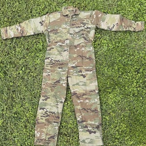 May include: A full-length jumpsuit featuring a multi-colored camouflage pattern in shades of olive green, tan, brown, and black. The garment includes a collared neckline, long sleeves, and a front button closure, with a straight-leg pant design.