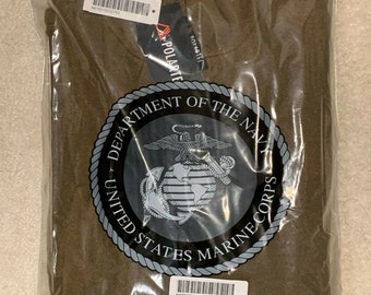 Puede incluir: Una sudadera de vellón marrón con cremallera. La sudadera tiene el logotipo del Cuerpo de Marines de los Estados Unidos en la parte delantera. La sudadera está empaquetada en una bolsa de plástico con una etiqueta que dice "CAGE: 4Z046 SHIRT PULLOVER FLEECE COYOTE SIZE: LARGE 1 EACH SPM1C1-07-0-N023 A"