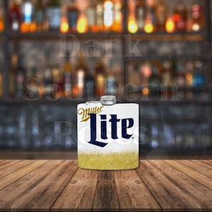 May include: White flask with a gold glitter bottom and a blue and white Miller Lite logo.