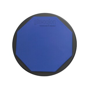 May include: A blue and black round drum pad with the text "okecajon co. handmade in Istanbul" on the top.