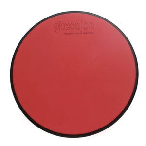 May include: Red round drum with a black rim and the text "okecajon handmade in Istanbul" printed on the top.