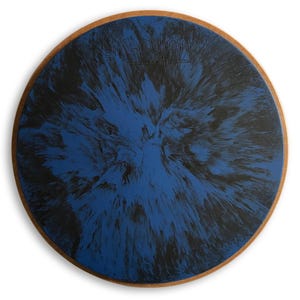 May include: A round blue and black patterned drum practice pad with a wooden rim. The pad has a black and blue marbled design.