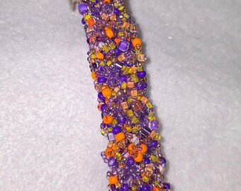 Barrette-Confetti, colorful purple and shades of orange, glass beads. Measures 4 inches.
