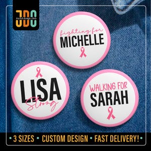 May include: Three round, white buttons with pink borders and text. One says "Fighting for Michelle", another "Lisa Strong", and the third "Walking for Sarah". Each has a pink ribbon symbol. The buttons are on a denim background.