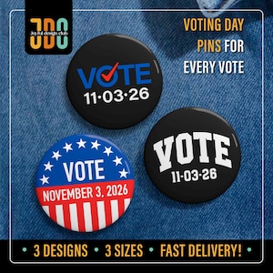 May include: Three circular pin-back buttons featuring voting themes. One black button displays the text VOTE with a red checkmark and 11.03.26. Another black button shows VOTE and 11.03.26 in white. A third button features a blue top with white stars, the text VOTE, and red and white stripes below with NOVEMBER 3, 2026.
