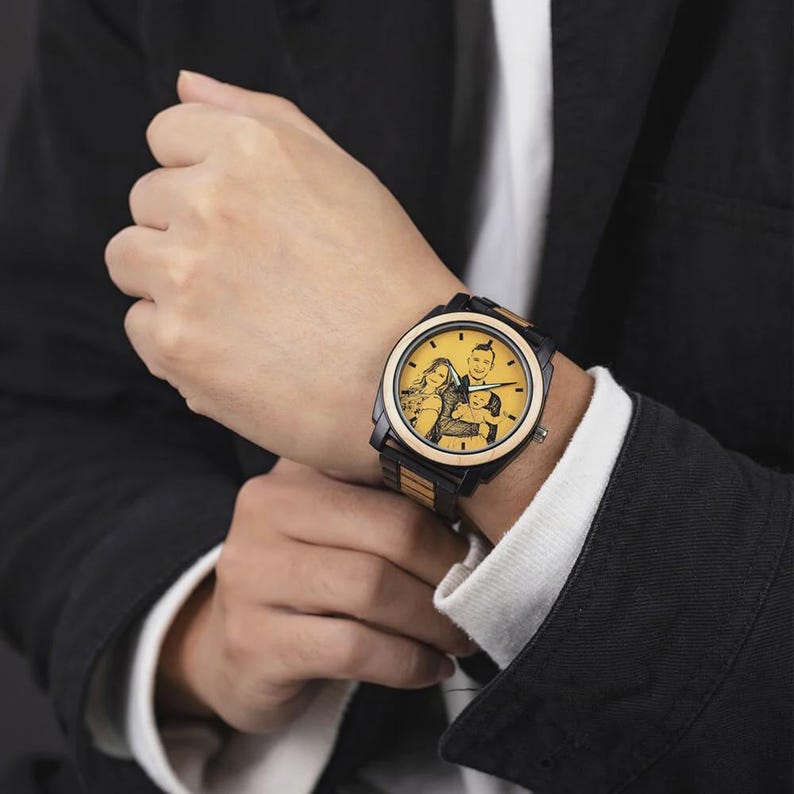 Op de afbeelding: Een zwart en houtkleurig polshorloge met een aangepaste foto op de wijzerplaat. Het horloge heeft een zwarte lunette en een band met afwisselende houten en zwarte schakels. De wijzerplaat toont een familieportret.