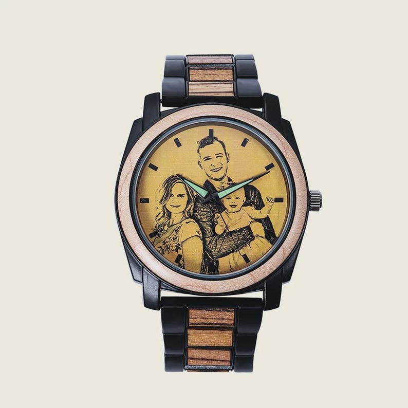 Op de afbeelding: Een gepersonaliseerd houten polshorloge met een zwart en houtkleurig bandje. De wijzerplaat van het horloge toont een sepia-getint familieportret. De wijzers van het horloge zijn groen. Het horloge heeft een roestvrijstalen kroon.