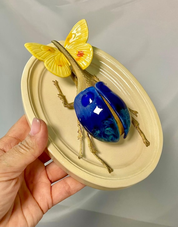 A gilded steampunk beetle sculpted in ceramic with magma-glaze detailing — looks like a Victorian entomologist's fever dream cast in clay and gold.