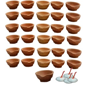 May include: A set of 30 terracotta diya lamps, traditional Indian oil lamps, arranged in rows. The diyas are a reddish-brown colour and have a small indentation for the wick. Three white cotton wicks are included.