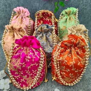 Peut inclure: Assortiment de sacs à cordon de couleur avec des embellissements de perles. Les sacs sont en tissu et présentent des motifs de broderie complexes.