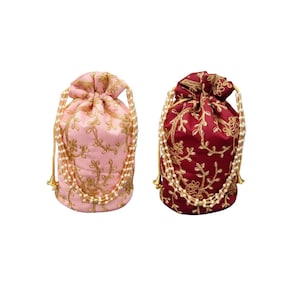May include: Two drawstring bags, one pink and one burgundy, are displayed against a white background. Both bags feature gold floral embroidery and are adorned with a pearl-like beaded trim. The bags have gold drawstrings.