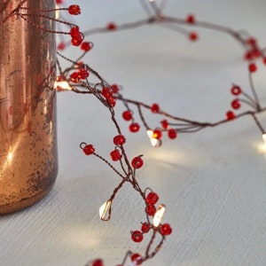 May include: A string of fairy lights with red beads, perfect for adding a festive touch to any space.