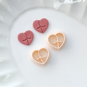 May include: Two pink heart-shaped cookie cutters and two pink heart-shaped fondant decorations.
