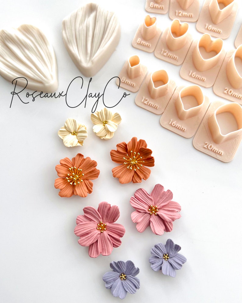 May include: A set of polymer clay flower making tools and supplies. The tools include a variety of sizes of heart and round cutters, and two silicone molds for creating flower petals. The image also shows several finished polymer clay flowers in various colors, including cream, orange, pink, and purple.