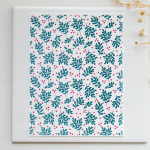 May include: A white card with a teal and pink floral pattern. The pattern features small teal leaves and pink dots.