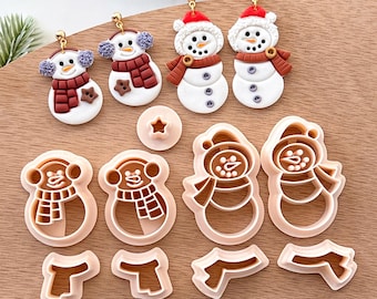 May include: A set of six snowman-themed cookie cutters. The cutters are made of white plastic and feature different designs, including a snowman with a hat, a snowman with a scarf, and a snowman with a star. The cutters are perfect for making festive cookies for the holidays.