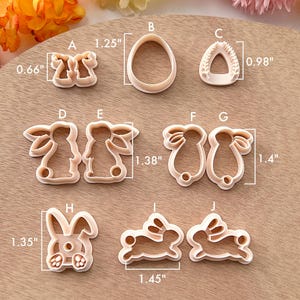 May include: Set of 10 cookie cutters in various shapes, including bunnies, eggs, and a heart. The cutters are made of white plastic and are approximately 1.25 inches to 1.45 inches in size.
