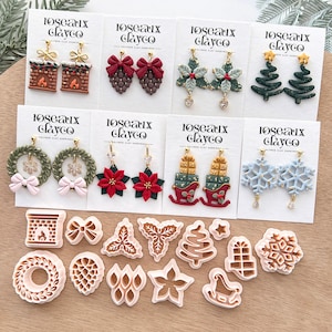 Peut inclure: Une collection de boucles d'oreilles et d'emporte-pièces en pâte polymère faits à la main. Les boucles d'oreilles présentent des motifs festifs tels que des sapins de Noël, des couronnes et des flocons de neige. Les emporte-pièces sont de formes variées.