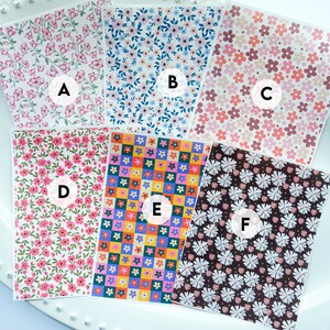 May include: Six different floral patterned sheets of paper, labelled A through F. The patterns include pink flowers on a white background, blue flowers on a white background, pink flowers on a beige background, pink flowers on a green background, colourful flowers in a checkered pattern, and white flowers on a brown background.