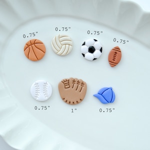 Pu&ograve; includere: Un set di sette ciondoli sportivi in ​​argilla colorata, tra cui una palla da baseball, una palla da basket, un pallone da calcio, una pallavolo, un guanto da baseball, un pallone da football americano e un berretto da baseball. I ciondoli hanno un diametro di circa 1,9 cm, ad eccezione del guanto da baseball, che ha un diametro di 2,5 cm.