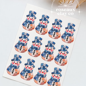 Könnte beinhalten: Ein rechteckiges Blatt mit zwölf identischen Illustrationen eines Schneemanns, der einen blau-weiß karierten Zylinder und Schal trägt. Jeder Schneemann hat einen Patchwork-Körper mit orangefarbenen und blauen Mustern, drei schwarze Knöpfe.