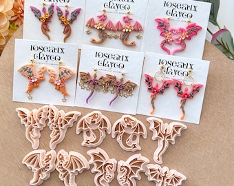 May include: A collection of polymer clay earrings featuring dragon designs in various colors, including pink, orange, and brown. The earrings are displayed on white cards with the text "Roseaux Clayco". Also included are several dragon-shaped clay cutters.
