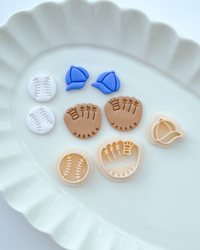 Pu&ograve; includere: Un set di nove topper e tagliapasta in pasta di zucchero a tema baseball. I topper includono due palline da baseball bianche, due guanti da baseball marroni e due cappellini da baseball blu. I tagliapasta includono una pallina da baseball bianca, un guanto da baseball marrone e un cappellino da baseball blu.