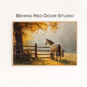 May include: A framed print depicting a horse near a wooden fence in a field. The artwork uses a warm colour palette, with a large tree and the text "BEHIND RED DOOR STUDIO" at the top.