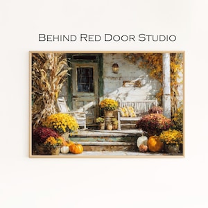 Könnte beinhalten: Ein gerahmter Druck einer gemütlichen Veranda-Szene mit einer weißen Bank, Kürbissen und Topf-Chrysanthemen in Gelb-, Orange- und Burgundertönen. Der Text "BEHIND RED DOOR STUDIO" ist sichtbar. Das Kunstwerk erzeugt eine warme, herbstliche Atmosphäre.