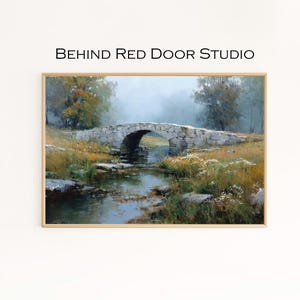 May include: Framed landscape art print featuring a stone bridge over a stream. The artwork depicts a serene scene with a bridge, water, and foliage in muted tones. The text "BEHIND RED DOOR STUDIO" is printed at the top.