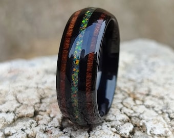 Anillo de tungsteno con concha de abulón e incrustaciones de ópalo galaxia en madera de koa hawaiana.