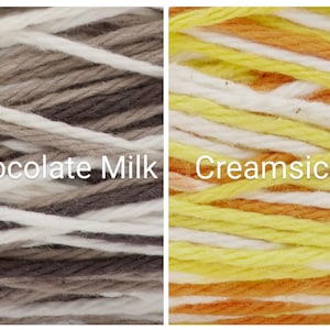 Puede incluir: Dos madejas de hilo, una etiquetada como "Chocolate Milk" con hebras blancas, marrones y beige, y la otra como "Creamsicle" con hebras amarillas, naranjas y blancas. El hilo est&aacute; bien enrollado, mostrando la textura y las variaciones de color.