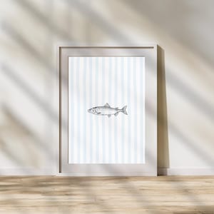 Puede incluir: Una impresión enmarcada de una ilustración estilizada en blanco y negro de un pez sobre un fondo a rayas azul claro y blanco.
