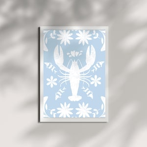 Puede incluir: Un fondo azul claro con una silueta de langosta blanca en el centro. La langosta está rodeada de un patrón de flores y peces blancos.