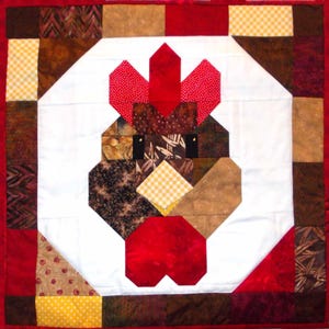 May include: A handmade quilt featuring a rooster design. The rooster's head is composed of various fabric patterns, including red polka dots, brown, and yellow gingham. The quilt has a white background and a red border.