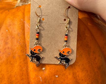 Spooky black cat with orange witch hat