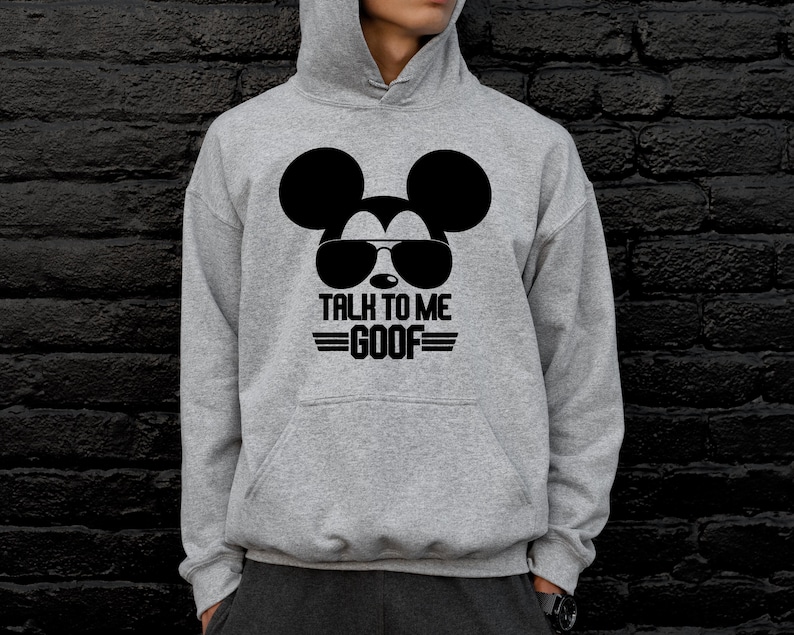 May include: A gray hooded sweatshirt featuring a black graphic of Mickey Mouse wearing sunglasses. Below the graphic, the text reads "TALK TO ME GOOF" in black. The sweatshirt has a front pocket and a drawstring hood.