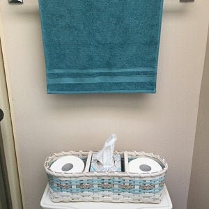 May include: White wicker bathroom storage basket with two rolls of toilet paper and a tissue box dispenser. The basket has a blue and white woven pattern.