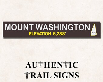 May include: A brown sign with white text that reads "Mount Washington Elevation 6,288'" with a yellow outline of the state of New Hampshire. The sign is labeled "Authentic Trail Signs".