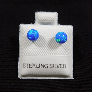 May include: A pair of sterling silver stud earrings with blue and green opal stones.