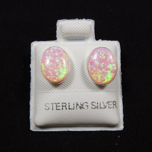 Peut inclure: Une paire de boucles d'oreilles en argent sterling avec des pierres d'opale rose. Les boucles d'oreilles sont de forme ovale et ont une finition brillante.
