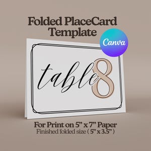May include: A folded place card template with the word "table" in elegant script and the number "8" in a soft beige color. The card has a black border and includes the text "For Print on 5" x 7" Paper". A Canva logo is in the upper right corner.