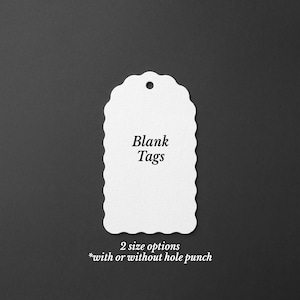 May include: A white scalloped tag with a hole punch at the top. The tag features the black text Blank Tags in the center. Below the tag, the text reads 2 size options *with or without hole punch. The design is simple and functional for labeling.