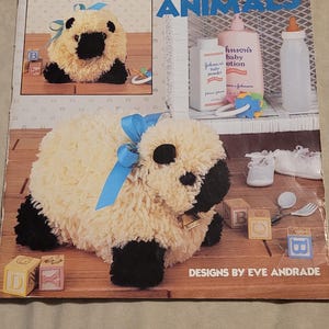 May include: A leaflet titled "Baby Latch Hook Animals" by Leisure Arts, featuring a sheep latch hook project. The cover shows a finished sheep, baby items, and the text "Designs by Eve Andrade."